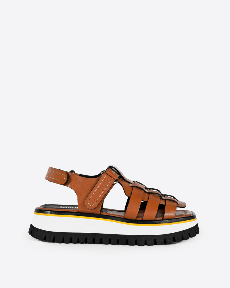 Brown sandal with a white and black chunky sole on a white background