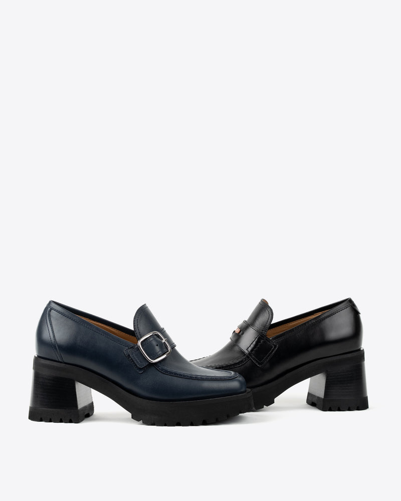 Pair of black and navy leather shoes with buckles on a white background