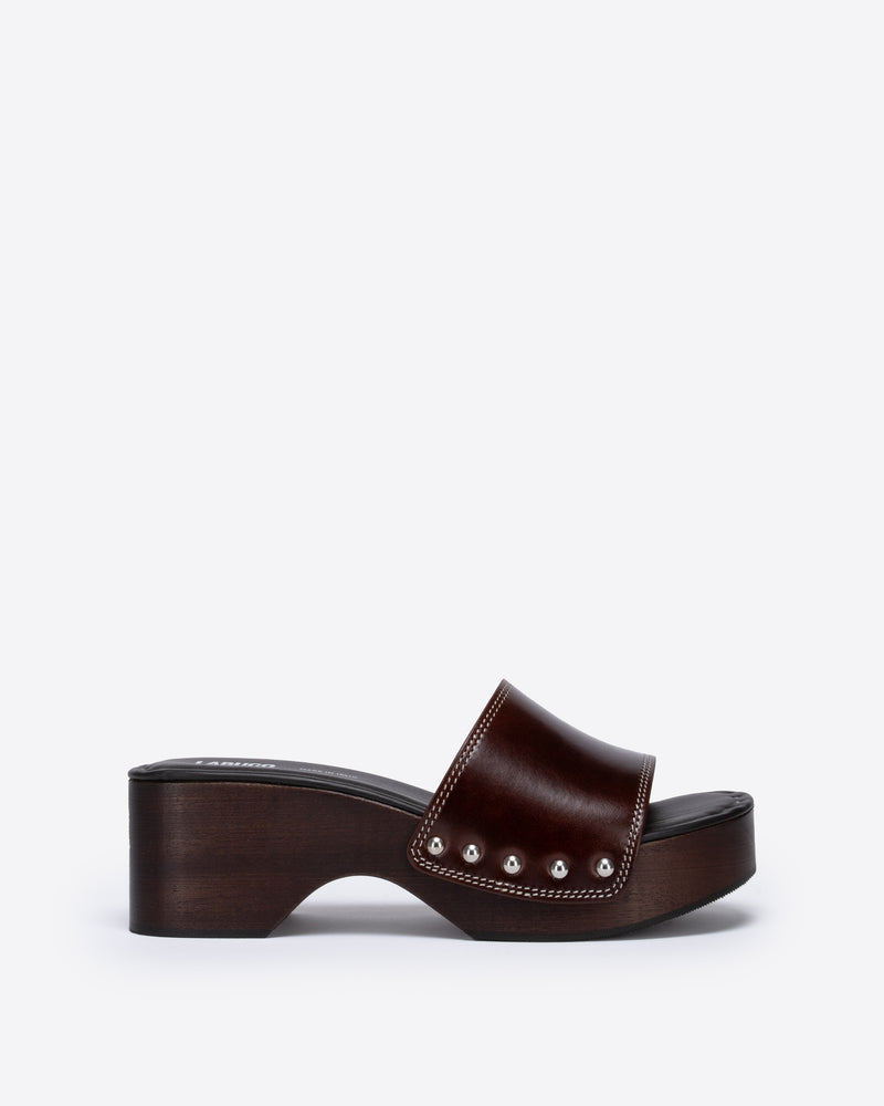 Brown wooden clog with a brown strap on a white background.